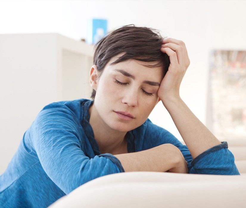 Woman holding head up tired