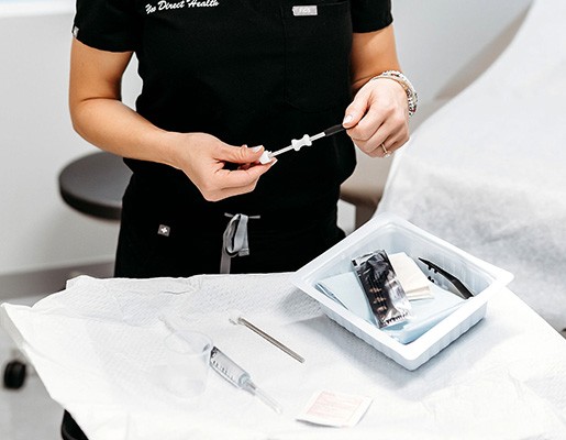 Medical professional prepping syringe for injection.