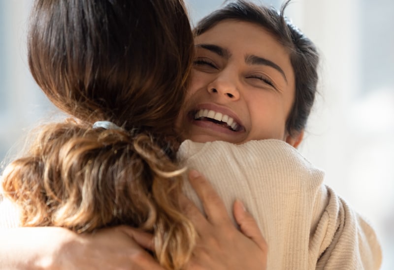 Smiling woman hugging a friend